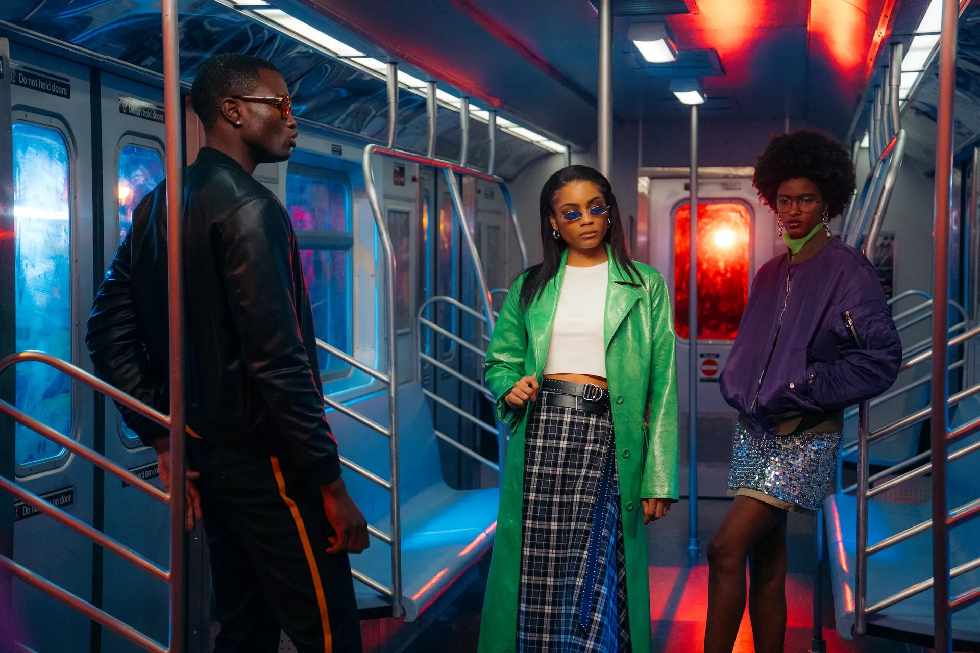 Three models pose in a New York subway set under blue and red lighting at the Sony A1 Mark II event.